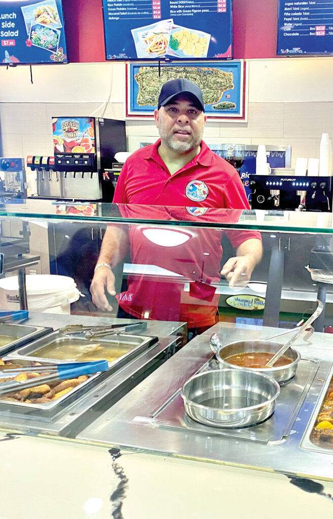 Chef Ismael Vega atiende clientes emocionado durante la inauguración de su restaurante Boriken. El reconocido chef comparte su alegría con los invitados mientras se prepara para ofrecer una experiencia culina-
ria auténtica llena de sabores puertorriqueños. 